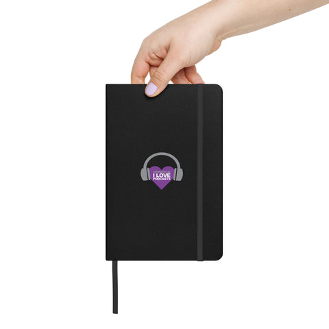 Image of A hand holding a Boss Uncaged Store: Boss Uncaged: Unleashing Ideas - I Love Podcasting" Hardcover Notebook with a purple logo on it, featuring the "I Love Podcasting" slogan from Boss Uncaged.