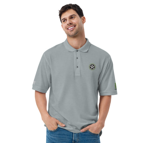 Image of A man wearing a Boss Uncaged Store grey polo shirt with a green logo.