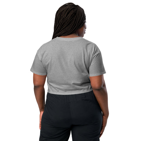 The back view of a woman wearing an Affirmation I Love Podcasts - Women's Crop Top from Boss Uncaged Store and black pants.