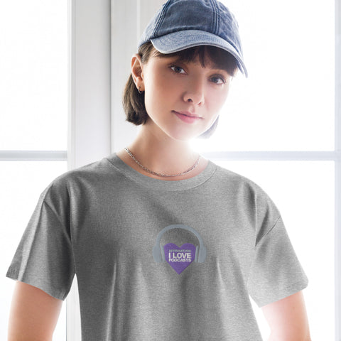 A woman confidently donning an Affirmation I Love Podcasts - Women's crop top from the Boss Uncaged Store, featuring a grey t-shirt with a stylish purple logo.