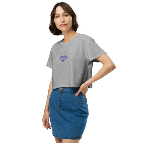 A woman wearing a Boss Uncaged Store Affirmation I Love Podcasts women's crop top with a purple heart on it.