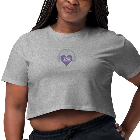 A woman wearing a grey Affirmation I Love Podcasts - Women's crop top with a purple heart on it, embracing her love for podcasts from Boss Uncaged Store.