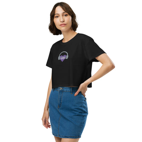 A stylish woman wearing an Affirmation I Love Podcasts - Women's crop top from Boss Uncaged Store with a purple logo on it.