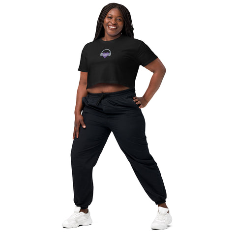 A woman confidently donning an Affirmation I Love Podcasts - Women’s crop top from Boss Uncaged Store and trendy joggers.