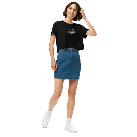 A stylish woman wearing an Affirmation I Love Podcasts - Women’s crop top from Boss Uncaged Store and a blue denim skirt.