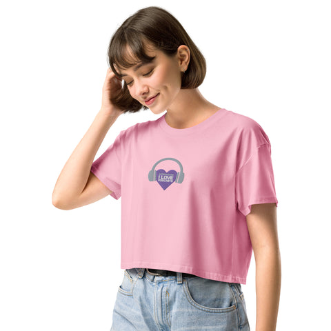 A woman wearing an empowering Affirmation I Love Podcasts - Women’s crop top from Boss Uncaged Store with a purple heart on it.