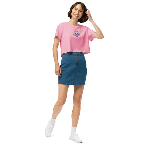 A woman wearing a pink t-shirt and blue skirt stylishly pairs a Boss Uncaged Store's Affirmation I Love Podcasts - Women’s crop top.