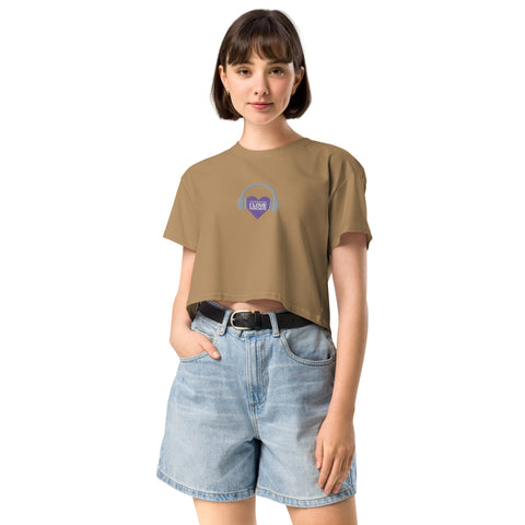 A stylish woman sporting a tan cropped t-shirt from Boss Uncaged Store, showcasing the Affirmation I Love Podcasts - Women’s crop top in the latest trend in women's crop tops, and complementing it with shorts.