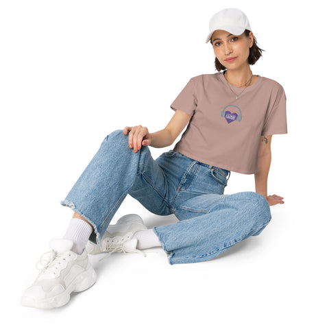 A woman wearing a Boss Uncaged Store's Affirmation I Love Podcasts - Women’s crop top and jeans listening to affirmations podcasts.
