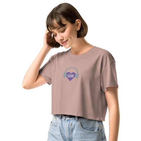 A woman wearing a Affirmation I Love Podcasts - Women’s crop top with a purple logo representing the Boss Uncaged podcast, which focuses on entrepreneurship and personal growth.