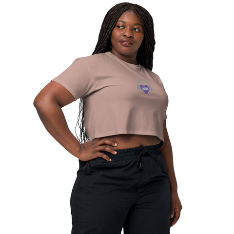 A woman, confidently dressed in an Affirmation I Love Podcasts - Women's crop top from the Boss Uncaged Store and black pants, embodies the essence of empowerment as she listens to the Boss Uncaged podcast.