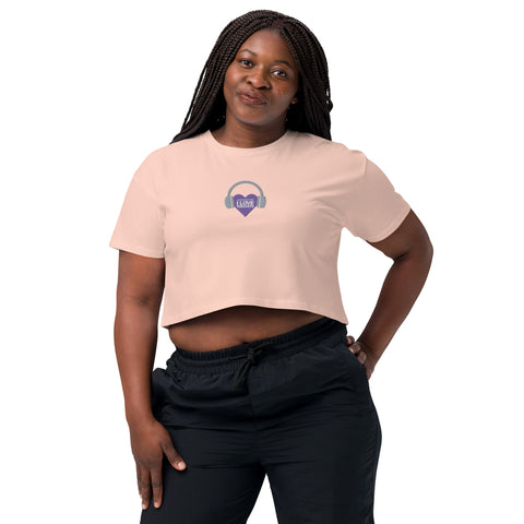 A woman wearing a Affirmation I Love Podcasts - Women's crop top from the Boss Uncaged Store confidently embraces her style while listening to the Boss Uncaged podcast.