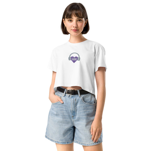 A woman wearing a white cropped t-shirt with a purple heart on it, embodying the Boss Uncaged ethos while tuning into Affirmation I Love Podcasts - Women’s crop top from the Boss Uncaged Store.