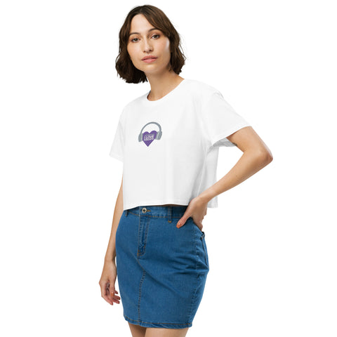 A trendy woman wearing a Boss Uncaged Store Affirmation I Love Podcasts - Women’s crop top and denim skirt, showing off the popular cropped length.