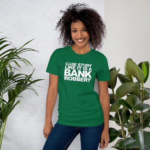 Image of A person wearing a green t-shirt with the text "CASE THE STUDY LIKE IT IS A BANK ROBBERY! GIMME THE LOOT!" stands smiling next to two potted plants against a plain wall, showcasing how Buteke's unique approach to case studies can bring your products to life and shape customer perception.