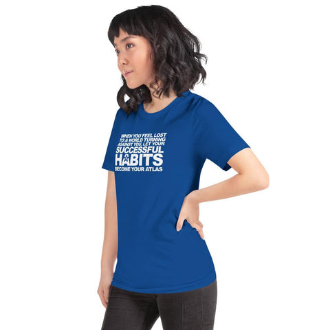 Image of A woman wearing a blue t-shirt with the words, "WHEN YOU FEEL LOST TO A WORLD TURNING AGAINST YOU, LET YOUR SUCCESSFUL HABITS BECOME YOUR ATLAS," from Boss Uncaged Store.