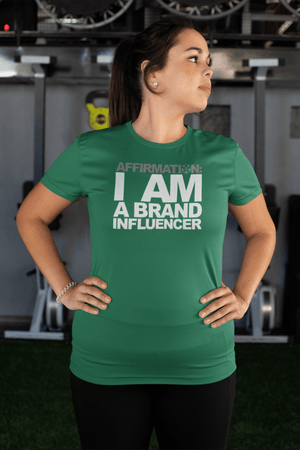 A woman wearing a green t-shirt that says "AFFIRMATION: I AM A BRAND INFLUENCER" from the Boss Uncaged Store.