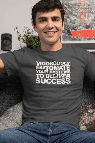 Image of A man sits on a couch, smiling and wearing a dark gray Buteke t-shirt with the text: "VIGOROUSLY AUTOMATE YOUR SYSTEMS TO DELIVER SUCCESS" in white letters, epitomizing the power of automation.